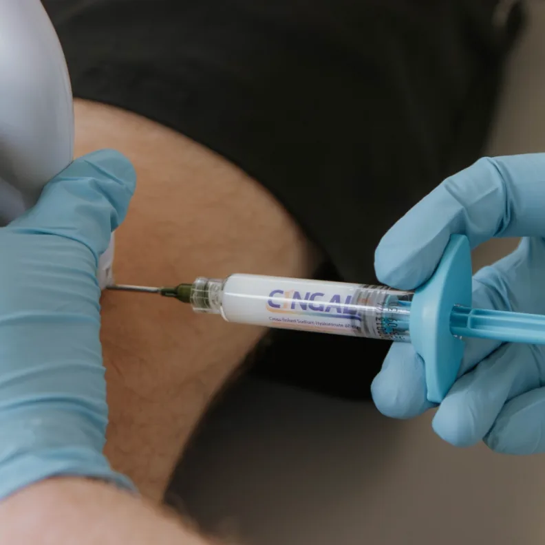 Clinician giving a knee joint injection